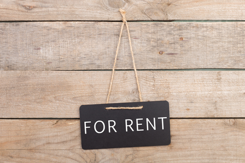 For-rent-sign-hanging-on-wood-wall