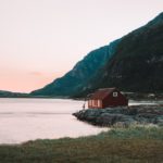 red-cabin-sitting-by-mountians-and-a-lake