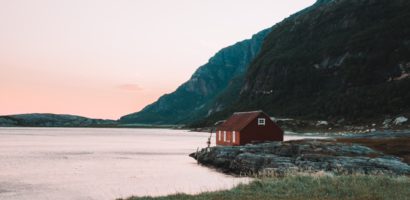 red-cabin-sitting-by-mountians-and-a-lake