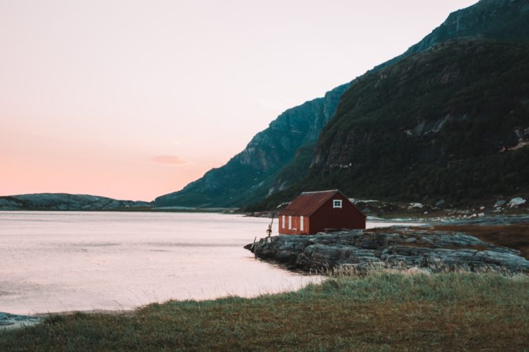 red-cabin-sitting-by-mountians-and-a-lake