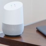 White Google Home on dark wooden table