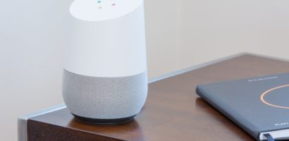 White Google Home on dark wooden table