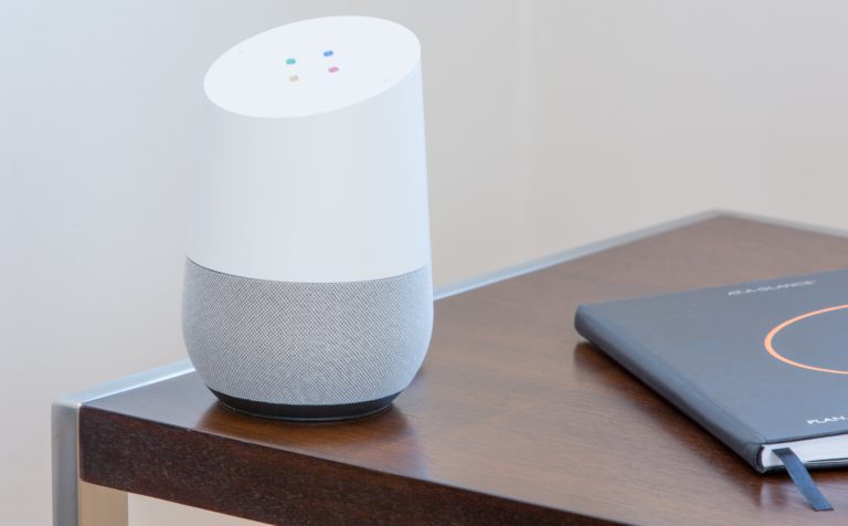 White Google Home on dark wooden table