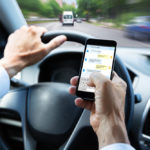 Person texting on cellphone while driving a vehicle