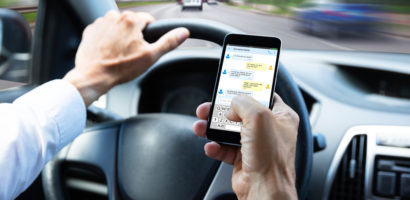 Person texting on cellphone while driving a vehicle