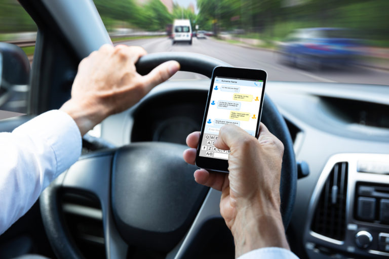 Person texting on cellphone while driving a vehicle