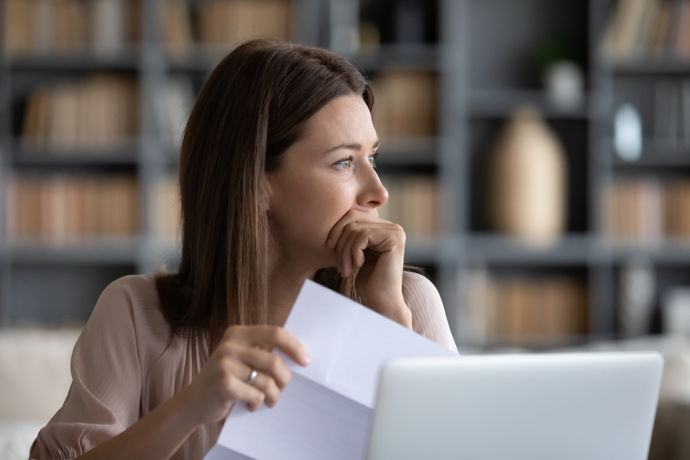 Stressed young woman holding paper document