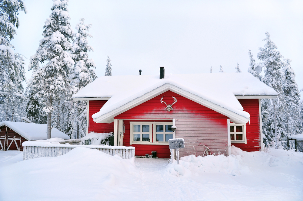 red wooden cottage in a snow landscape
