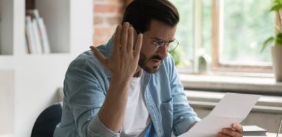 Condo owner reacts to a special assessment notice while reviewing documents at home