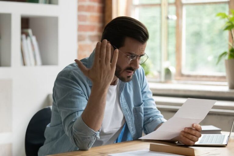 Condo owner reacts to a special assessment notice while reviewing documents at home
