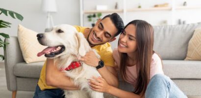 Couple sitting on the floor at home while petting their dog