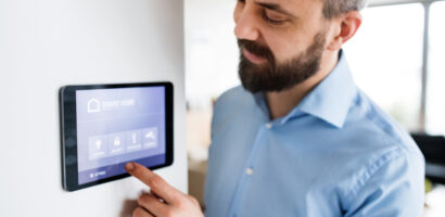 A man pointing to a tablet with smart home screen at home.