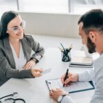 Client discusses coverage options with an insurance advisor while signing paperwork