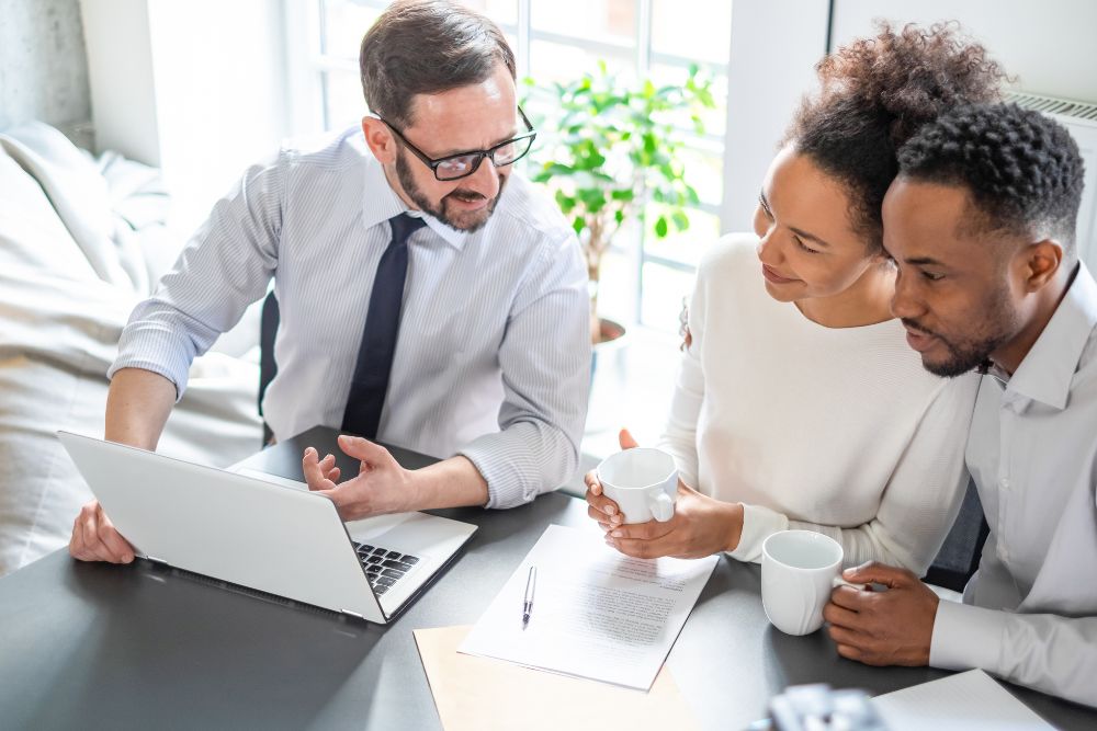 young couple sits at table with insurance broker discussing insurance options