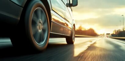 Close-up of a vehicle driving on a highway at sunset